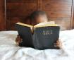 Lille dreng læser i Bibelen.